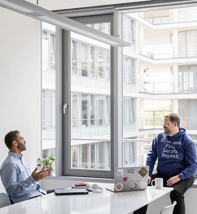 Två anställda pratar med varandra på ett kontor 