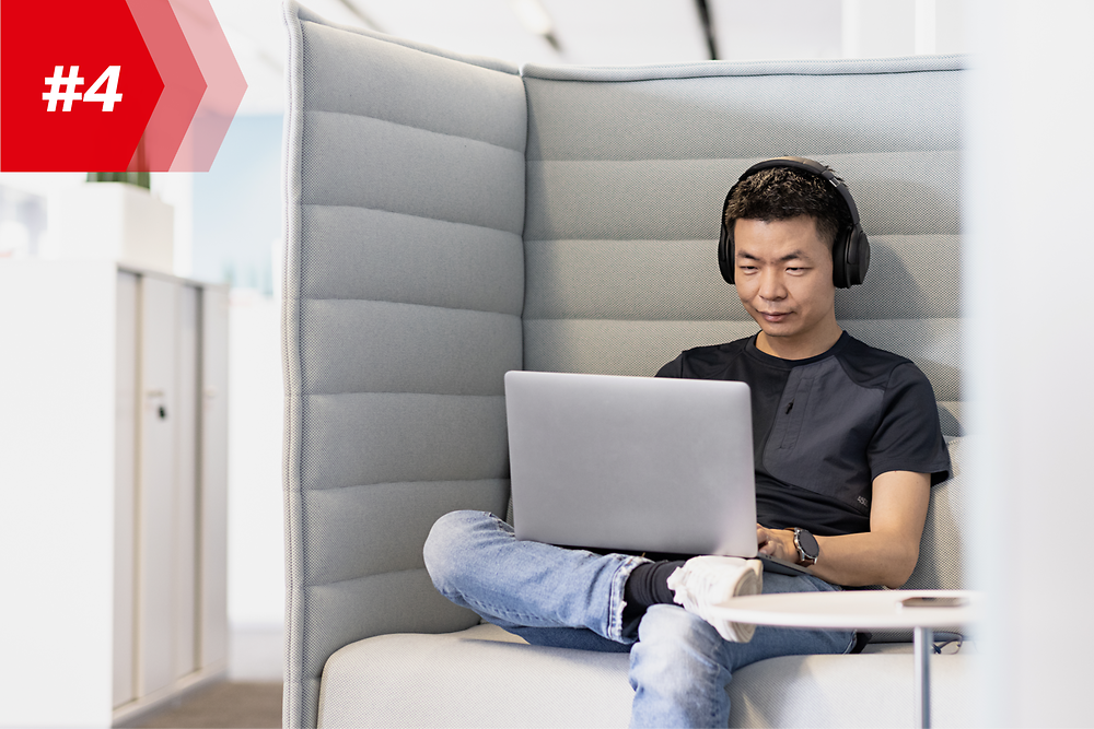 Henkel-anställde Hao, chef för Mobile App Factory, med hörlurar och sin bärbara dator