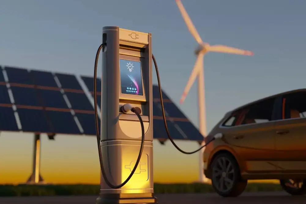 Laddstation för elfordon med solpaneler och vindkraftverk i bakgrunden.