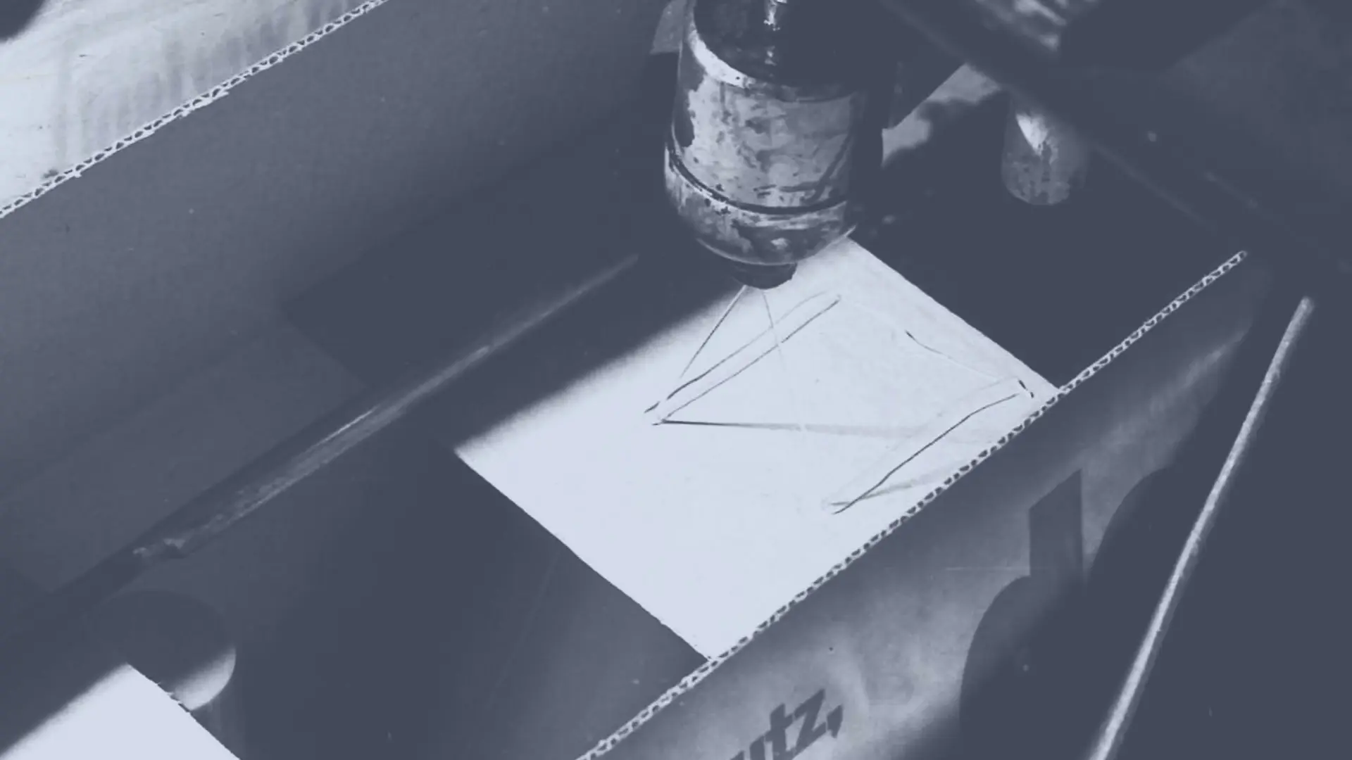 Technomelt smältlim appliceras på en kartong med ett spruthuvud för att försegla den.